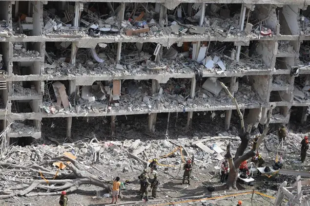 Squadre di emergenza israeliane lavorano sul sito di un attacco missilistico iraniano su un complesso residenziale a Tel Aviv, Israele, 22 giugno 2025. Israele e Iran si scambiano colpi di fuoco da quando Israele ha lanciato attacchi in Iran il 13 giugno 2025.