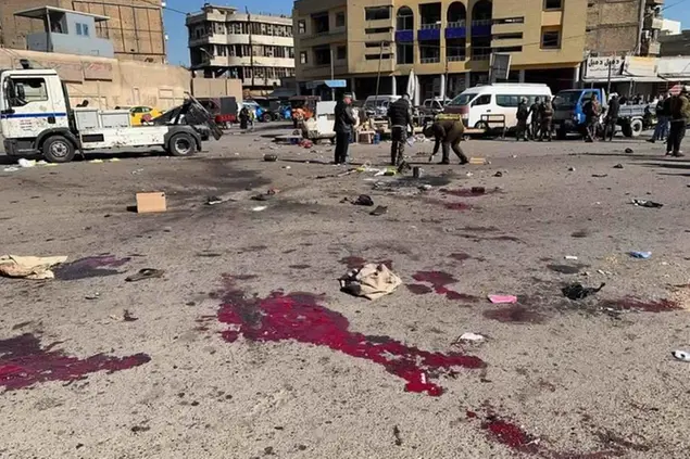 Security forces work at the site of a deadly bomb attack in a market selling used clothes, Iraq, Thursday, Jan. 21, 2021. Twin suicide bombings hit Iraq\\\\'s capital Thursday killing and wounding civilians, police and state TV said.