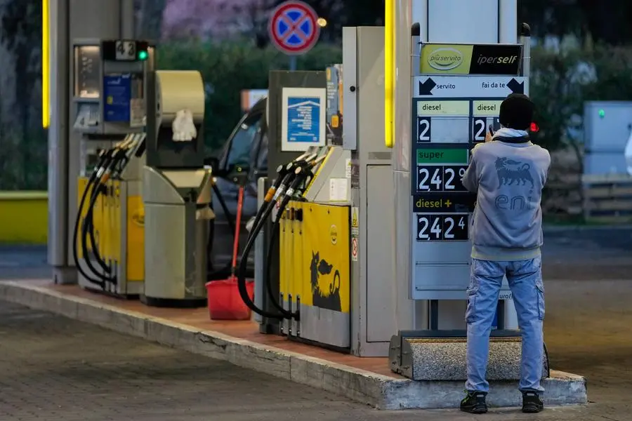 A gas station attendant changes fuel prices on a board at a gas station in Milan, Italy, Thursday, March 10, 2022. Car fuel price in Italy recently exceeded the 2.00 euros per liter threshold due to the turmoil on the international oil market caused by the war in Ukraine, and on Thursday morning drivers found a new record high at the gas stations with fuel touching 2.40 euros per liter records. (AP Photo/Luca Bruno)