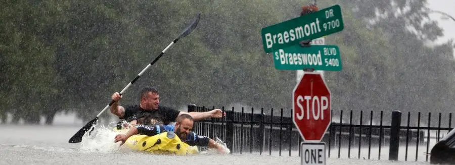 FILE - In this Sunday, Aug. 27, 2017. file photo, two kayakers try to beat the current pushing them down an overflowing Brays Bayou from Tropical Storm Harvey in Houston, Texas. The Intergovernmental Panel on Climate Change report released on Monday, Aug. 9, 2021, says warming already is smacking Earth hard and quickly with accelerating sea level rise, shrinking ice and worsening extremes such as heat waves, droughts, floods and storms. (Mark Mulligan/Houston Chronicle via AP, FIle)