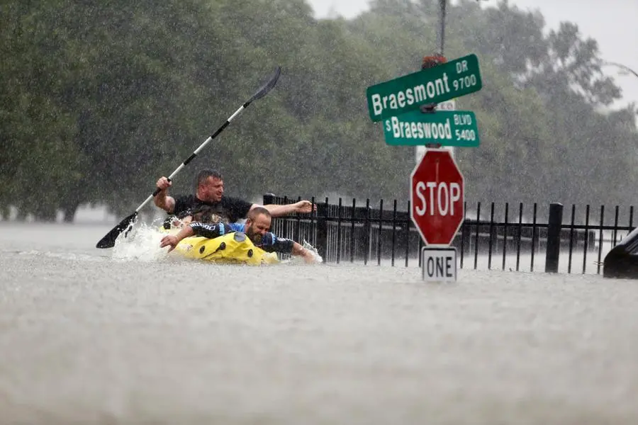 FILE - In this Sunday, Aug. 27, 2017. file photo, two kayakers try to beat the current pushing them down an overflowing Brays Bayou from Tropical Storm Harvey in Houston, Texas. The Intergovernmental Panel on Climate Change report released on Monday, Aug. 9, 2021, says warming already is smacking Earth hard and quickly with accelerating sea level rise, shrinking ice and worsening extremes such as heat waves, droughts, floods and storms. (Mark Mulligan/Houston Chronicle via AP, FIle)
