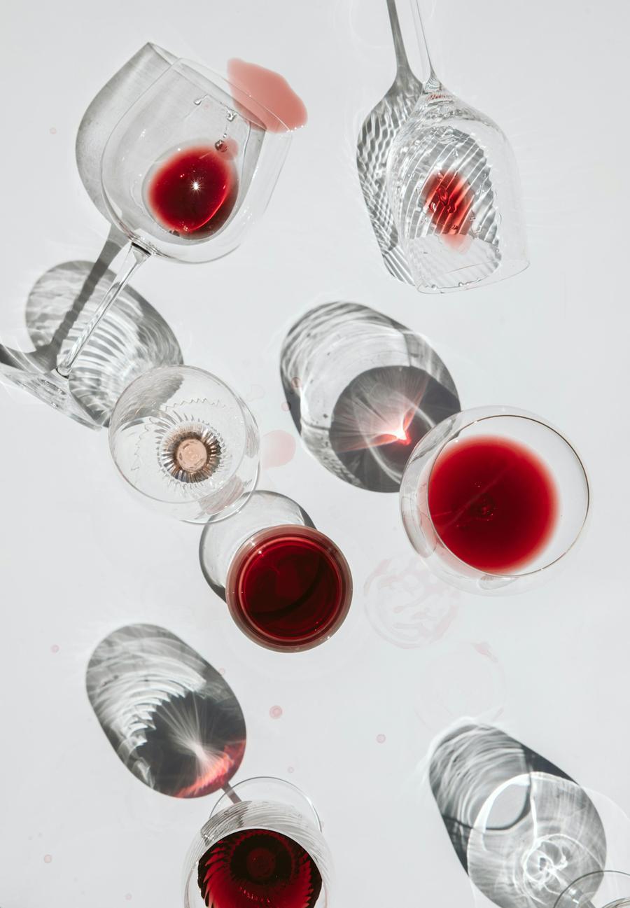 Un bicchiere di vino in un ambiente informale, con persone che lo condividono, in un contesto di crisi e cambiamenti di abitudini