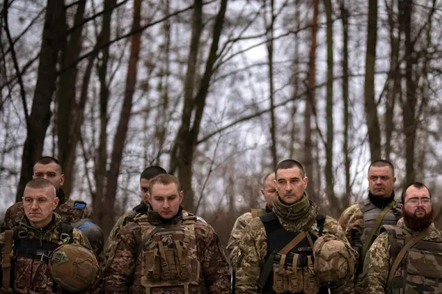 Ukrainian servicemen of the Prince Roman the Great 14th Separate Mechanized Brigade stand in formation during a flag ceremony where some of them were honored for their bravery and accomplishments in battle, in the Kharkiv area, Ukraine, Saturday, Feb. 25, 2023. (AP Photo/Vadim Ghirda)