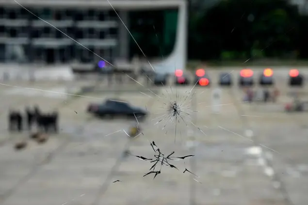A strong security presence is set up at the Esplanade of Ministries, as seen through a window that was damaged when supporters of former President Jair Bolsonaro stormed the area on Sunday, at the Planalto Palace, in Brasilia, Brazil, Wednesday, Jan. 11, 2023, ahead of new expected protests called by Bolsonaro supporters. (AP Photo/Eraldo Peres)