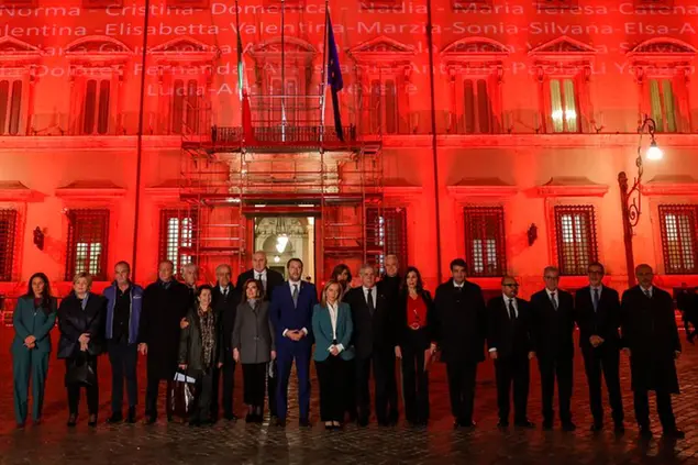 Con Palazzo Chigi illuminato di rosso alla vigilia della giornata, la presidente del Consiglio posa con i suoi ministri (Foto Agf)