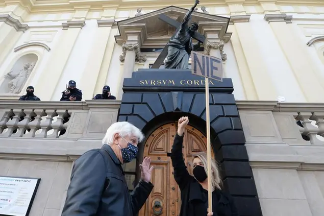 (Una ragazza polacca esprime il suo dissenso al divieto di aborto davanti a una chiesa della capitale, domenica 25 ottobre. Foto LaPresse)
