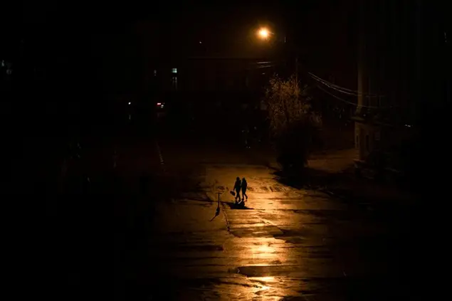 Persone passeggiano a Kiev, in Ucraina, durante un blackout domenica 6 novembre (AP Photo/Andrew Kravchenko)