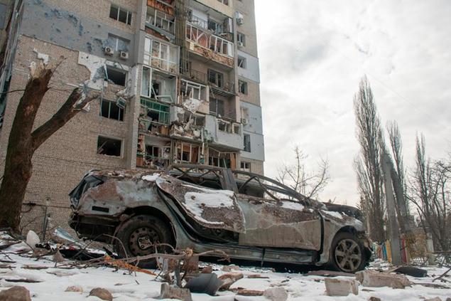 A destroyed car in front of a building damaged by shelling, in Kharkiv, Ukraine, Sunday, March 13, 2022. (AP Photo/Andrew Marienko)