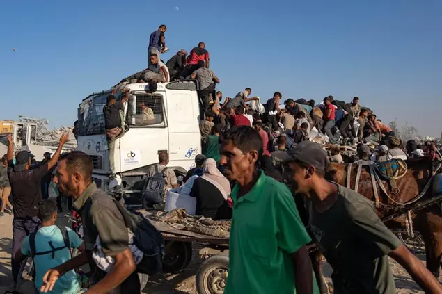 Un gruppo di sfollati palestinesi sale su un camion di aiuti umanitari il 4 agosto a sud di Khan Younis