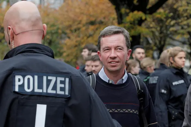 16 October 2019, Hamburg: Bernd Lucke, economist and AfD co-founder, is standing in front of police officers on campus after his prevented inaugural lecture at the University of Hamburg. Several hundred demonstrators have prevented the first lecture of AfD co-founder Bernd Lucke at the University of Hamburg since his return to the university. Photo by: Markus Scholz/picture-alliance/dpa/AP Images