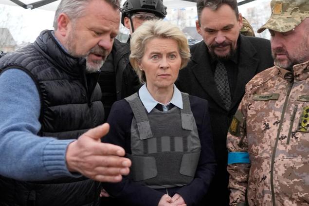 EU Commission President Ursula von der Leyen, center, visits a mass grave in Bucha, outskirts of Kyiv, Ukraine, Friday, April 8, 2022. An international organization formed to identify the dead and missing from the 1990s Balkan conflicts is preparing to send a team of forensics experts to Ukraine as the death toll mounts more than six weeks into the war caused by Russia's invasion. (AP Photo/Efrem Lukatsky)