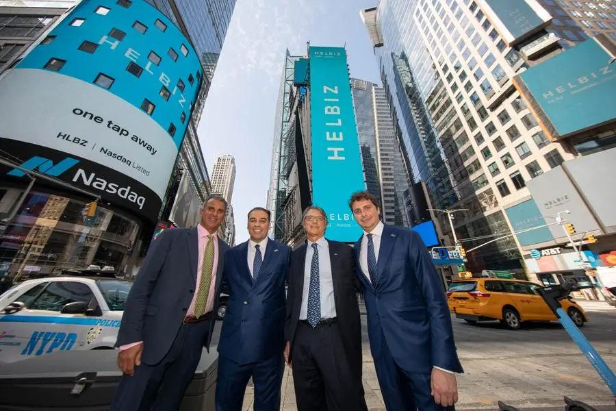 (L-R) Helbiz board member Guy Adami, Founder and CEO of Helbiz Salvatore Palella, Helbiz board member Lee Stern and Chief Financial Officer Giulio Profumo pose outside the Nasdaq MarketSite in Times Square while celebrating being the first U.S. publicly listed shared micro-mobility company on Friday, August 13, 2021 in New York. (Andrew Kelly/AP Images for Helbiz)
