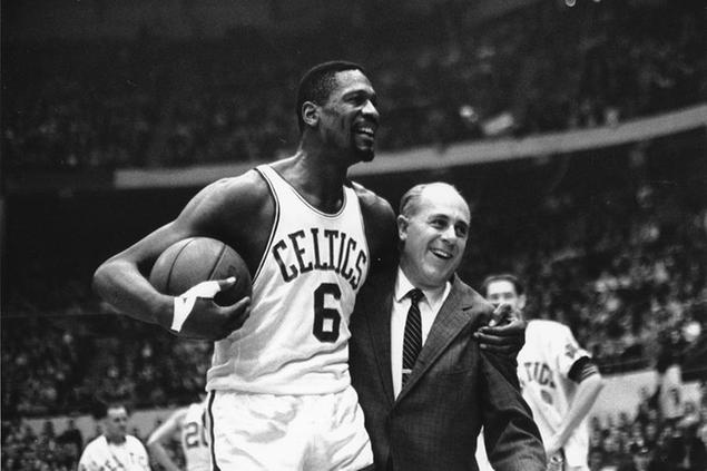 FILE - Bill Russell, left, star of the Boston Celtics is congratulated by coach Arnold \\\"Red\\\" Auerbach after scoring his 10,000th point in the NBA game against the Baltimore Bullets in Boston Garden on Dec. 12, 1964. The NBA great Bill Russell has died at age 88. His family said on social media that Russell died on Sunday, July 31, 2022. Russell anchored a Boston Celtics dynasty that won 11 titles in 13 years. (AP Photo/Bill Chaplis, file)