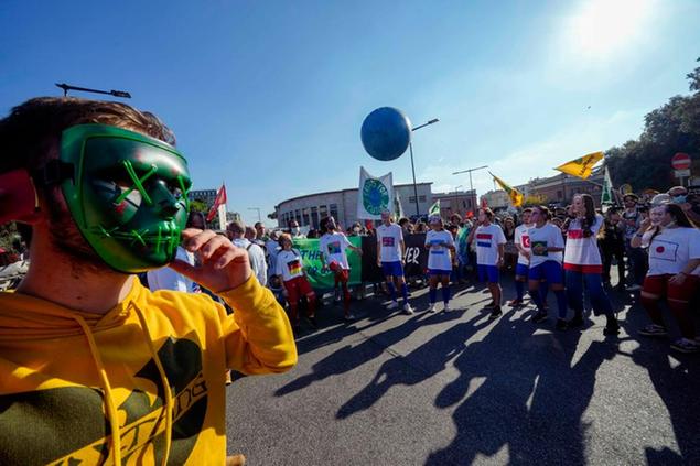 Demonstrators wearing cut-off masks with faces of world leaders stage a mock soccer game with a ball symbolizing the planet hearth during a march in Rome, Saturday, Oct. 30, 2021, the day a Group of 20 summit started in the Italian capital. Factory workers, climate activists, antiglobalization campaigners, unions, feminist groups, vaccine skeptics and political extremists are seizing the opportunity to voice anger while world's leaders are gathering in town for the first time in presence since the COVID-19 pandemic started in 2019. (AP Photo/Luca Bruno)