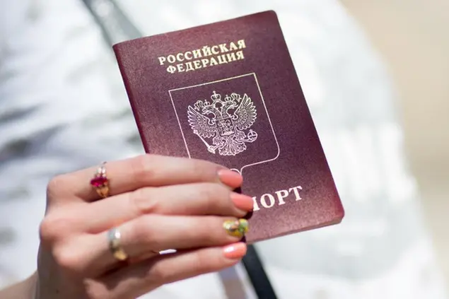 A woman holds a Russian passport in her hands at the Estonian town of Narva at the border crossing to Russia, Estonia, 02 June 2016. Narva has approximately 60,000 inhabitants, the third largest city in the Baltic state. Photo by: Kay Nietfeld/picture-alliance/dpa/AP Images