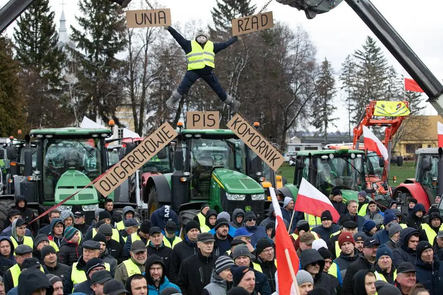 Gli agricoltori polacchi protestano a Czerniszyn, vicino al confine con l’Ucraina. Il manifesto recita “Ue”, “Governo” e, in basso da sinistra, “Oligarchi” e “Pignoramento”. Jakub Orzechowski / Agencja Wyborcza.pl