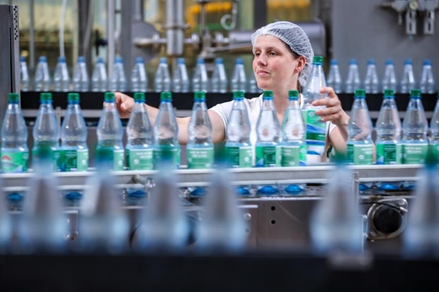 22 June 2022, Saxony, Lichtenau: Food technician Madlen Kruske monitors the mineral water filling line at Lichtenauer Mineralquellen GmbH. The company in the Ore Mountains with a good 225 employees fills an average of 700,000 bottles of mineral water and soft drinks. In recent weeks, however, the \\\"sound barrier\\\" of one million liters of beverages has been exceeded several times. A lack of empties causes problems for the producers in the summer. Photo by: Jan Woitas/picture-alliance/dpa/AP Images