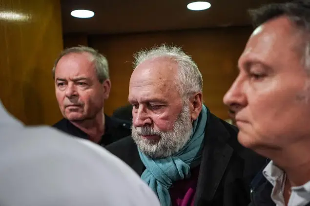 FILE - In this Jan.13, 2020 file photo, former French priest Bernard Preynat, center, arrives at the Lyon court house, central France. Preynat, who acknowledged sexually abusing at least 75 boys over decades was sentenced Monday March 16, 2020 to five years in prison, in France's worst case of clergy abuse to reach trial. (AP Photo/Laurent Cipriani, File)