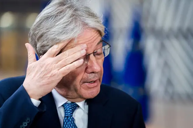 European Commissioner for Economy Paolo Gentiloni speaks with journalists as he arrives for a meeting of eurogroup finance ministers at the European Council building in Brussels on Monday, Dec. 6, 2021. (AP Photo/Geert Vanden Wijngaert)