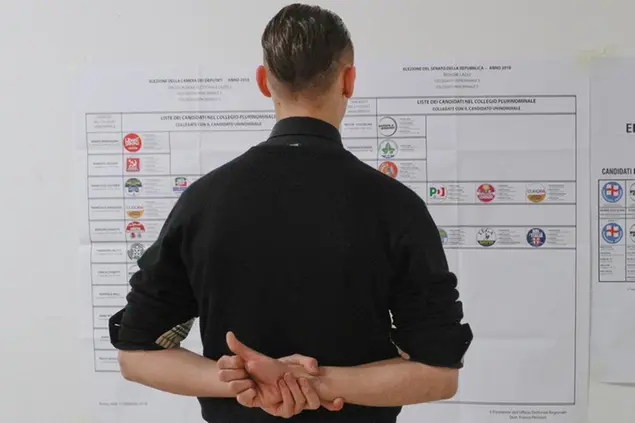 A man reads a poster displaying the list of the candidates at a polling station on the occasion of the Italian general elections in Fiuggi, Italy, Sunday, March 4, 2018. (AP Photo/Gregorio Borgia)