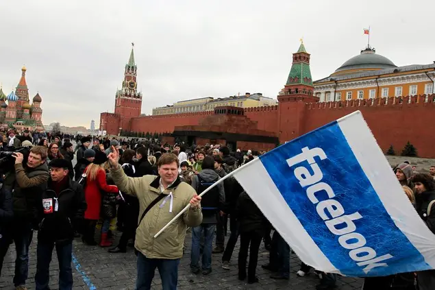 Opposition supporter waves a Facebook flag during a protest at the Red Square in Moscow, Sunday, April 8, 2012. Opposition activists called for supporters to walk around Red Square on Sunday wearing the white ribbons that have become a symbol of the protest movement against Prime Minister Vladimir Putin. Putin will begin serving a third presidential term in May. (AP Photo/Sergey Ponomarev)