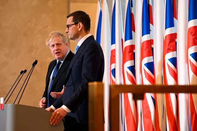 Britain's Prime Minister Boris Johnson, left, and Polish Prime Minister Mateusz Morawiecki take part in a press conference at the Chancellery, in Warsaw, Poland, Tuesday, March 1, 2022. (Leon Neal/Pool Photo via AP)