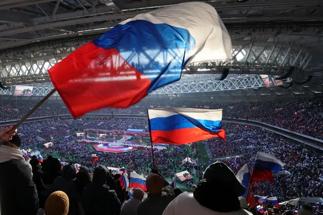 Participants wave Russian national flags during the ''Glory to the Defenders of the Fatherland'' concert waiting for Russian President Vladimir Putin, a day before the Defender of the Fatherland Day, a holiday honoring Russia's armed forces at the Luzhniki Stadium in Moscow, Russia, Wednesday, Feb. 22, 2023. (AP Photo)