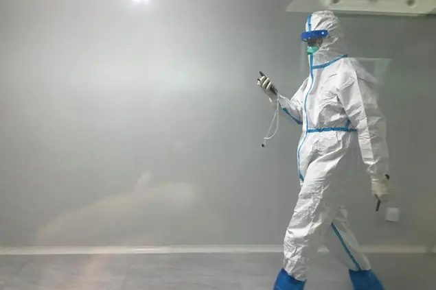 A worker in protective gear walks through a corridor in Guangzhou Baiyun Airport in southern China's Guangdong province on Dec. 25 2022. China will drop a COVID-19 quarantine requirement for passengers arriving from abroad starting Jan. 8, the National Health Commission announced Monday, Dec, 26, 2022 in the latest easing of the country's once-strict virus-control measures. (AP Photo/Emily Wang Fujiyama)