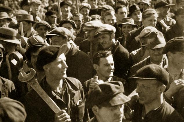 Factory workers with their tools celebrate the traditional Socialist holiday, Germany, 1936. May 1st, the German Workers' National Holiday. From \\\"Germany: The Olympic Year\\\", published by Volk und Reich Verlag. (Berlin, 1936).