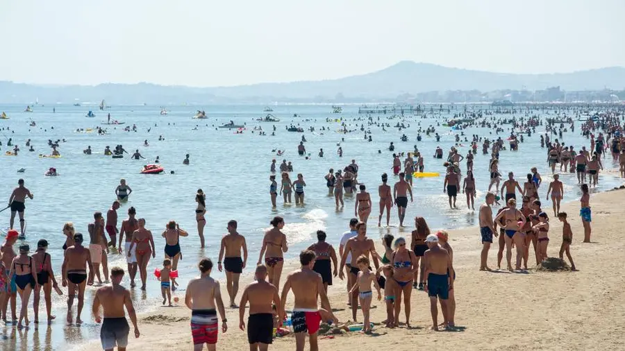 Lavoratori stagionali in spiaggia, con contratti irregolari e salari bassi, vigilano sulle vacanze