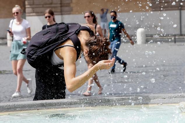 A woman refreshes herself at a fountain in downtown Rome, Tuesday, Aug. 10, 2021. Temperatures are expected to go over 45 degrees in some parts of Italy in the next days. (AP Photo/Riccardo De Luca)