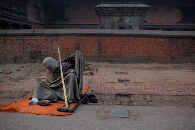A Nepalese homeless man sits and waits for alms near Pashupatinath temple premises in Kathmandu, Nepal, Monday, Jan. 18, 2016. The world's political and business elite are being urged to do more than pay lip service to growing inequalities around the world as they head off for this week's World Economic Forum in the Swiss ski resort of Davos. According to Oxfam, the scale of the problem is increasingly stark: just 62 people, it says, own the same wealth as half the planet. The compares with 388 people just five years ago, when the global economy was just emerging from its deepest recession since World War II. (AP Photo/Niranjan Shrestha)
