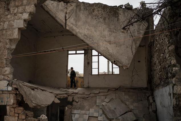In this Thursday, March 12, 2020 photo, a boy stands inside a house destroyed by an airstrike, in Idlib, Syria. Idlib city is the last urban area still under opposition control in Syria, located in a shrinking rebel enclave in the northwestern province of the same name. Syria\\u2019s civil war, which entered its 10th year Monday, March 15, 2020, has shrunk in geographical scope -- focusing on this corner of the country -- but the misery wreaked by the conflict has not diminished. (AP Photo/Felipe Dana)