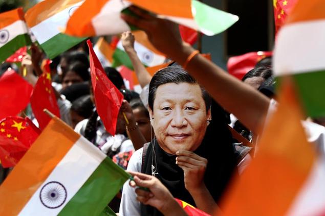 FILE- In this Oct. 10, 2019 file photo, an Indian schoolgirl wears a face mask of Chinese President Xi Jinping to welcome him on the eve of his visit in Chennai, India. India and China sought Wednesday, June 17, 2020, to de-escalate tensions following a fatal clash along a disputed border high in the Himalayas that left 20 Indian soldiers dead. The skirmish Monday in the desolate alpine area of Ladakh, in Kashmir, followed changes by India to the political status of Kashmir amid a geopolitical tug-of-war with the United States in the region. (AP Photo/R. Parthibhan, File)