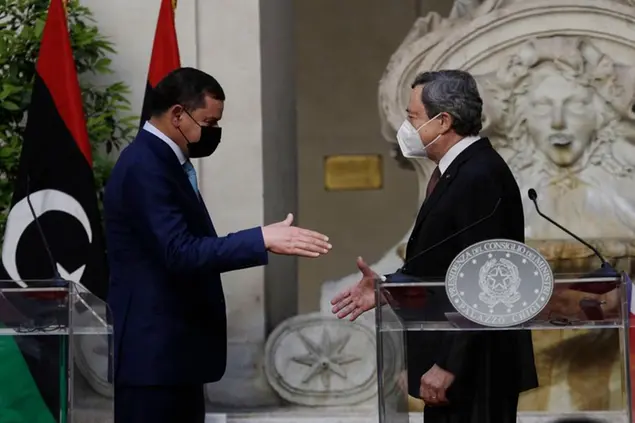 Italian Prime Minister Mario Draghi, right, and Libyan Prime Minister Abdulhamid Dbeibeh shake hands at the end of their meeting at Chigi palace, Premier's office, in Rome, Monday, May 31, 2021. (AP Photo/Gregorio Borgia, Pool)