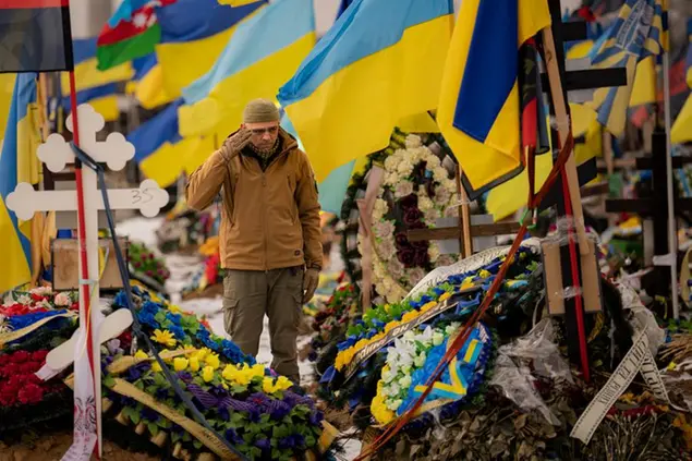 A Ukrainian serviceman salutes standing between the graves of soldiers during the funeral of Hennadii Kovshyk, who was killed on the frontline in eastern Ukraine, in Kharkiv, Ukraine, Thursday, Feb. 16, 2023. Russia again pummeled Ukraine with a barrage of cruise and other missiles on Thursday, hitting targets from east to west as the war 's one-year anniversary nears, one of the strikes killed a 79-year-old woman and injured at least seven other people, Ukrainian authorities said. (AP Photo/Vadim Ghirda) Associated Press/LaPresse Only Italy and Spain