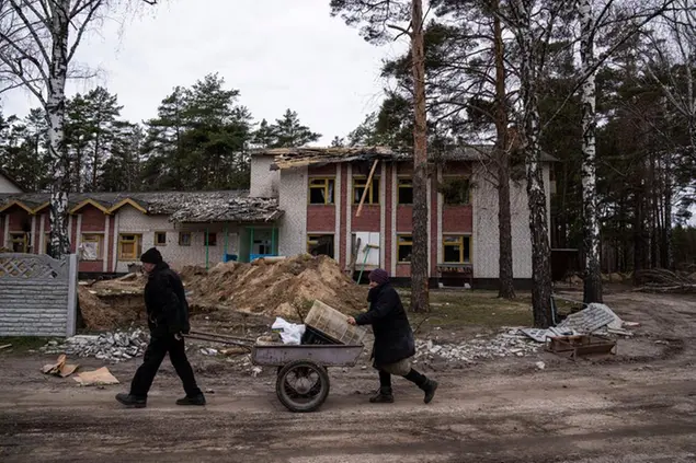 Un uomo\\u00A0e la moglie trasportano in una carriola del cibo\\u00A0che hanno recuperato\\u00A0a Yahidne, vicino a Dnipro, in Ucraina. La foto è del 12 aprile \\u00A0(AP)