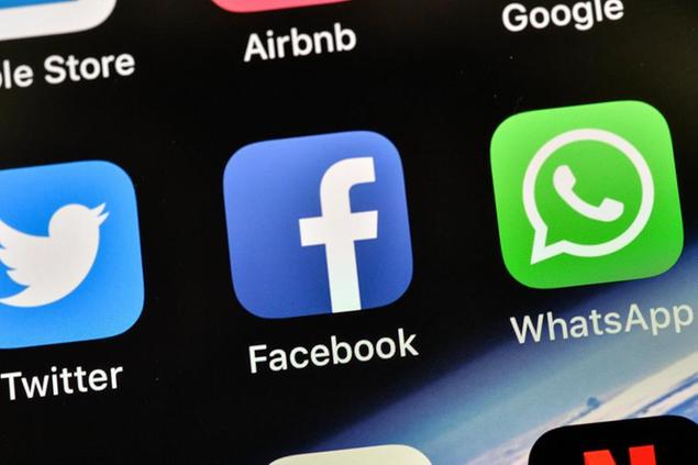 FILE - In this Thursday, Nov. 15, 2018 file photo, the icons of Facebook and WhatsApp are pictured on an iPhone, in Gelsenkirchen, Germany. Facebook's WhatsApp faces a complaint from European Union consumer groups who say the chat service has been unfairly pressuring users to accept a new privacy update, in a breach of the bloc's regulations. (AP Photo/Martin Meissner, FIle)