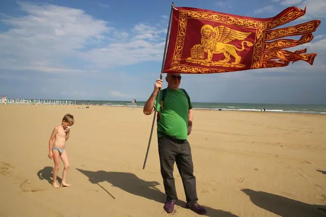 Un militante leghista sventola la bandiera della Lega Veneta sulla spiaggia di Jesolo FOTO AGF