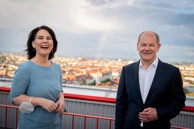 German Green Party co-chairwoman and the party's candidate for chancellor Annalena Baerbock, left, and f Olaf Scholz, Vince Minister candidate for chancellor of the Social Democratic Party, SPD stand on the roof terrace of RBB public broadcaster prior to a TV show in Berlin, Germany, Monday, May 17, 2021. (Kay Nietfeld/dpa via AP)