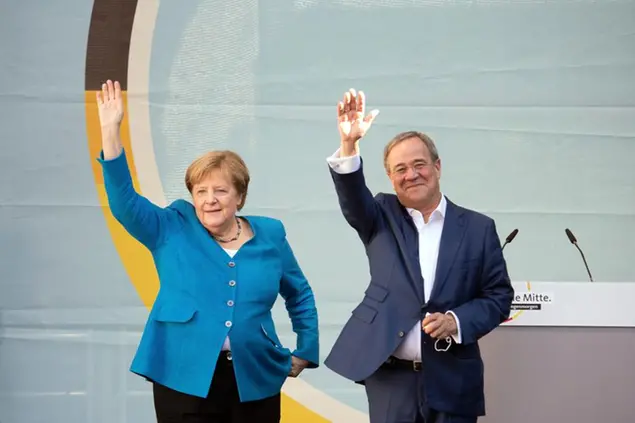 25 September 2021, North Rhine-Westphalia, Aachen: German Chancellor Angela Merkel (CDU) and Armin Laschet, Minister President of North Rhine-Westphalia, Federal Chairman of the CDU and top candidate of his party, stand on stage and wave during a joint campaign appearance. Voters are called to elect a new Bundestag on Sunday. Photo by: Federico Gambarini/picture-alliance/dpa/AP Images