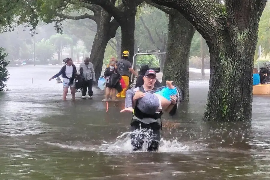 This photo provided by Orange County Fire Rescue's Public Information Office, Orange County firefighters help people stranded by Hurricane Ian early Thursday, Sept. 29, 2022 in Orange County, Fla. Ian marched across central Florida on Thursday as a tropical storm after battering the state’s southwest coast, dropping heavy rains that caused flooding and led to inland rescues and evacuations. (Orange County Fire Rescue's Public Information Office via A)