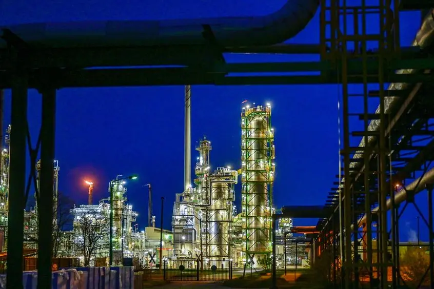 The facilities of the oil refinery on the industrial site of PCK-Raffinerie GmbH are illuminated in the evening in Schwedt, Germany, Wednesday, May 4, 2022. Crude oil from Russia arrives at the oil refinery via the \\\"Friendship\\\" pipeline. The Russian energy company Rosneft took over a large part of the refinery last year. Rosneft is Russia's largest oil producer. According to its own information, the plant in the Uckermark region processes 12 million tons of crude oil annually, making it one of the largest processing sites in Germany. (Patrick Pleul/dpa via AP)