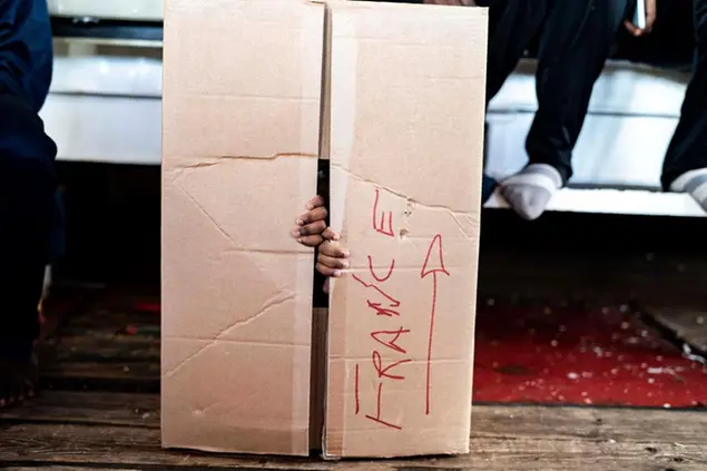 A child plays in a box aboard the humanitarian ship Ocean Viking heading to France with 230 migrants saved from the Mediterranean Sea, Thursday, Nov. 10, 2022. (AP Photo/Vincenzo Circosta)