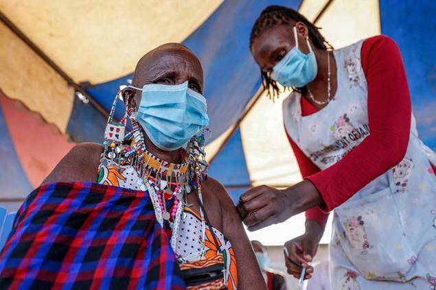 A Maasai woman receives the AstraZeneca coronavirus vaccine at a clinic in Kimana, southern Kenya Saturday, Aug. 28, 2021. Wealthier nations are awash in vaccines, while they are scarce in poorer countries and many people are still waiting for their first shot. (AP Photo/Brian Inganga)