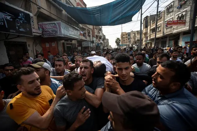 Mourners carry the body of Palestinian Tamim Hijazi, who was killed in an Israeli air strike, during his funeral in Khan Yunis in the southern Gaza Strip, Saturday, Aug. 6, 2022. Israeli jets pounded militant targets in Gaza as rockets rained on southern Israel, hours after a wave of Israeli airstrikes on the coastal enclave killed at least 11 people, including a senior militant and a 5-year-old girl. The fighting began with Israel's dramatic targeted killing of a senior commander of the Palestinian Islamic Jihad continued into the morning Saturday, drawing the sides closer to an all-out war. (AP Photo/Yousef Masoud)