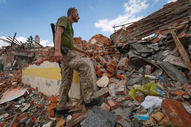 A Ukrainian serviceman looks at the rubble of a school that was destroyed some days ago during a missile strike in outskirts of Kharkiv, Ukraine, Tuesday, July, 5, 2022. (AP Photo/Andrii Marienko)