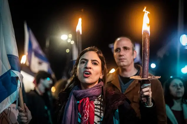 14 January 2023, Israel, Tel Aviv: A'protester holds a torch during a demonstration against the new government in Tel Aviv. Photo by: Ilia Yefimovich/picture-alliance/dpa/AP Images