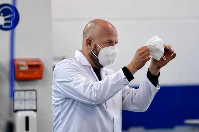 Manager Christian Vorbau of mask producer Sentias controls the production of FFP2 face masks against the spread of the coronavirus in Wuppertal, Germany, Thursday, Jan. 28, 2021. Germany introduced new rules for the types of mask to wear when travelling on public transport or shopping. Medical masks became mandatory to fight the COVID-19 pandemic. (AP Photo/Martin Meissner)