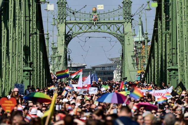 People march across the Szabadsag, or Freedom Bridge over the River Danube in downtown Budapest during a gay pride parade in Budapest, Hungary, Saturday, July 24, 2021. Rising anger over policies of Hungary's right-wing government filled the streets of the country's capital on Saturday as thousands of LGBT activists and supporters marched in the city's Pride parade. (AP Photo/Anna Szilagyi)